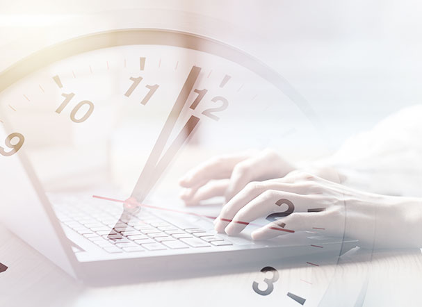 Cut-out image of hands typing on a computer. And above the image is the transparency of a clock.