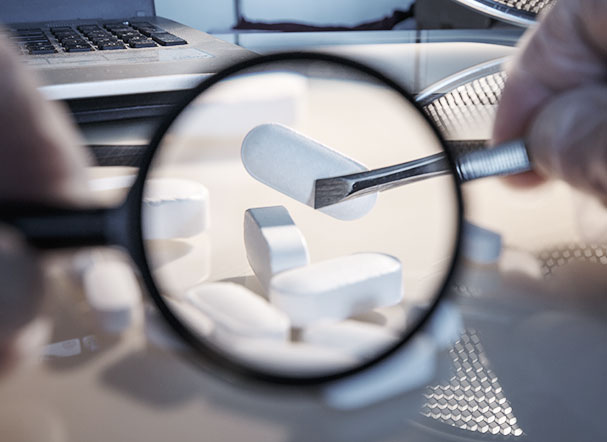 Magnifying glass focusing on white medicine capsules