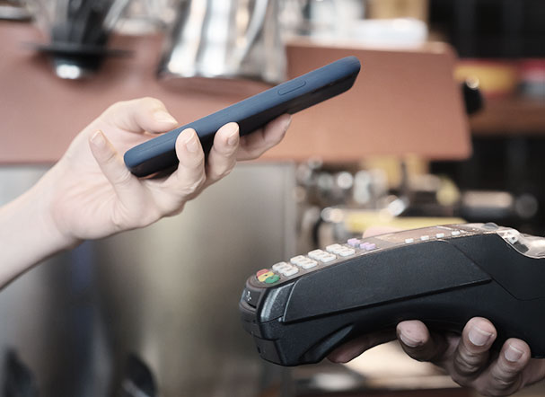 A person making a payment using a cell phone.